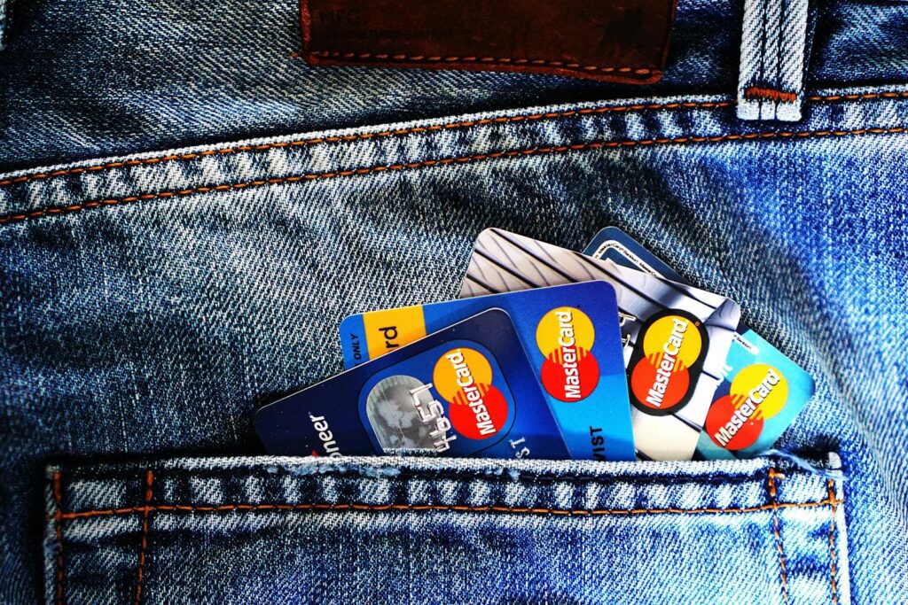 Pessoa com vários cartões de crédito no bolso, ilustrando a ideia de aumentar o limite de crédito e ter mais flexibilidade financeira para suas compras.