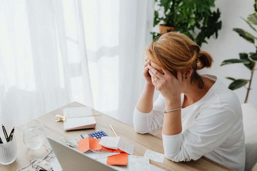 Mulher preocupada com sair das dívidas e buscando uma solução para a revisão de juros abusivos. A Cote Juros pode ajudar a aliviar esse peso, identificando cobranças indevidas e oferecendo um caminho para reduzir o valor das parcelas e recuperar o controle financeiro.