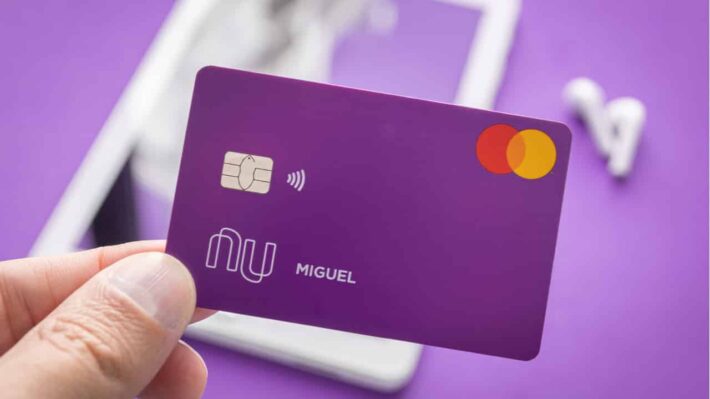 Pessoa segurando um cartão do Nubank, ilustrando como aumentar o limite do Nubank e aproveitar mais benefícios financeiros com o cartão de crédito.