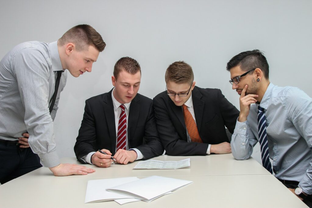 Grupo de gerentes bancários em reunião assinando um contrato, representando estratégias eficazes para resolver dívidas bancárias com condições vantajosas.