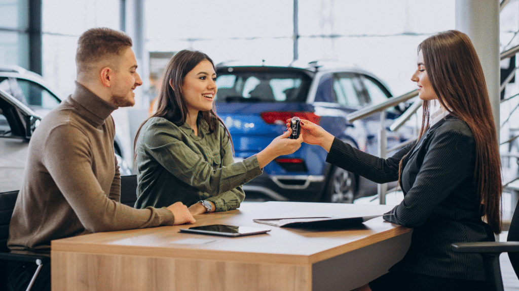 Casal assinando contrato de financiamento de carro em concessionária, mostrando como é possível financiar mesmo com nome sujo.
