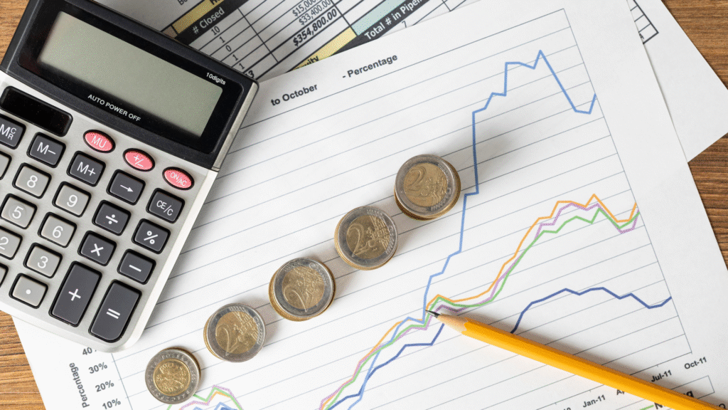 Calculadora ao lado de moedas e gráficos, simbolizando o acompanhamento do PIB e o planejamento financeiro.